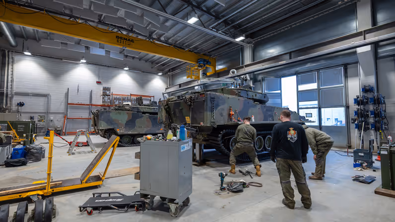 Militairen werken aan een militair voertuig.