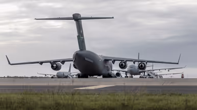 een C-17 transportvliegtuig staat vanaf de achterkant gezien voor 3 A330 MRTT’s.