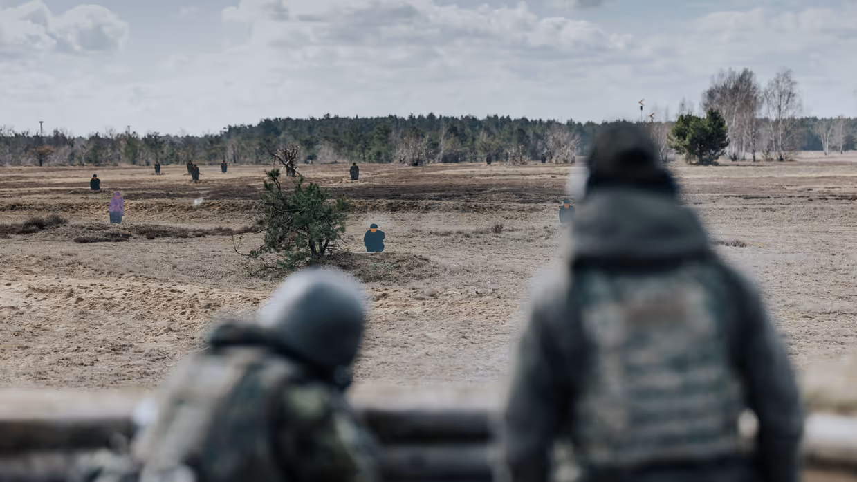 Oekraïners schieten vanuit loopgraaf, militair richt op klapschijven, Oekraïners liggen achter mitrailleur