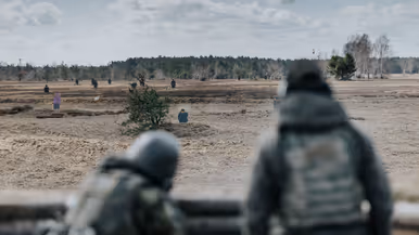 Oekraïners schieten vanuit loopgraaf, militair richt op klapschijven, Oekraïners liggen achter mitrailleur