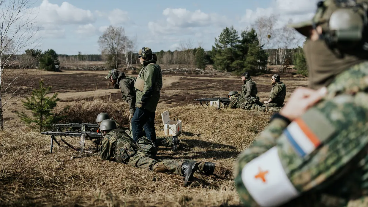 Militairen achter mitrailleur. 