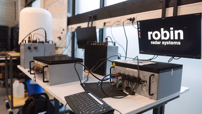 Een werkplaats vol met apparatuur. Op de achtergrond een droneradar. 