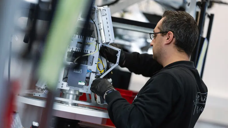 Een medewerker van Robin Radar werkt aan het binnenwerk van een IRIS-radar, zoals te zien op de headerfoto. 