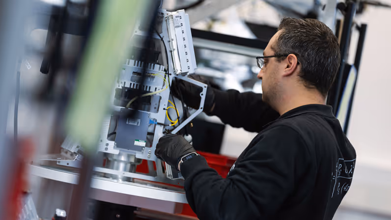 Een medewerker van Robin Radar werkt aan het binnenwerk van een IRIS-radar, zoals te zien op de headerfoto. 