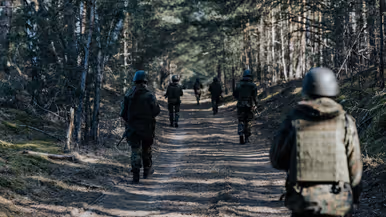 Cadetten lopen patrouille in bos 