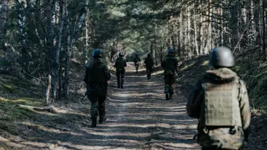 Cadetten lopen patrouille in bos 