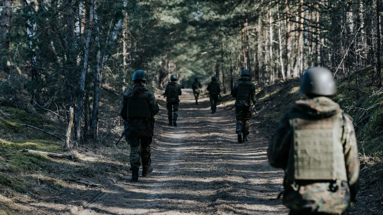 Cadetten lopen patrouille in bos 