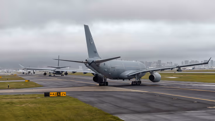 Een A330 MRTT draait naar links een taxibaan op. Daarvoor taxiet een tweede exemplaar en verder naar voren zijn civiele vliegtuigen te zien.