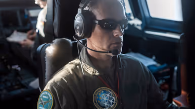 Portret van adjudant JP van der Velden, met een koptelefoon en een speciale bril op.