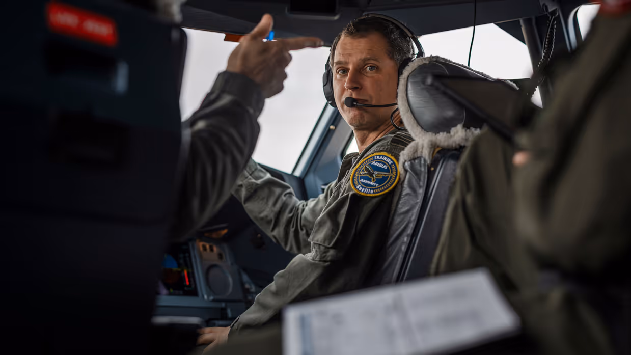 Een vlieger zit in de cockpit van de A330 MRTT en kijkt over zijn schouder achterom.