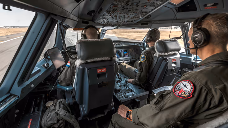 Blik over de linkerschouder van de ARO in de cockpit van een A330 MRTT als deze op de startbaan staat. De twee vliegers zitten voor hem in de cockpit.