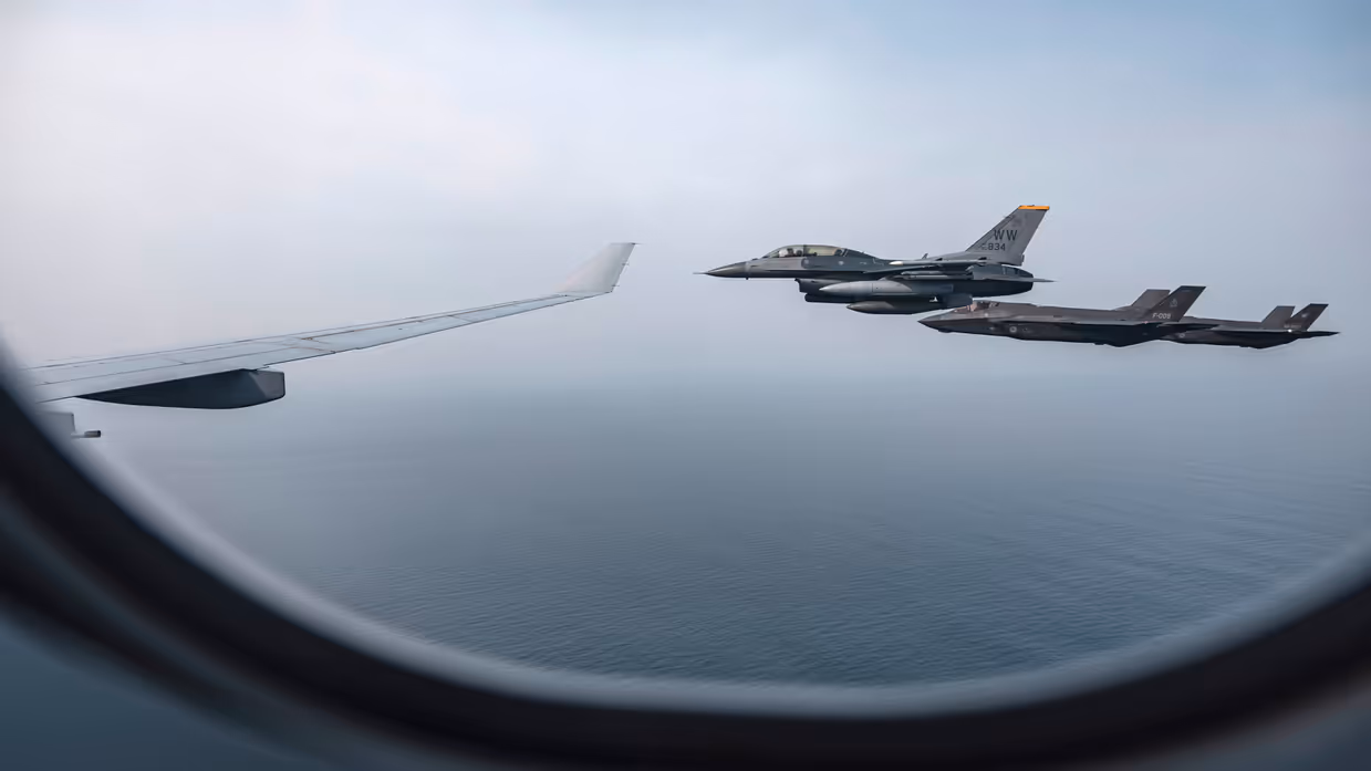 Beeld uit een raampje van een A330 MRRT. Te zien zijn de rechtervleugel van het toestel met daarnaast een Amerikaanse F-16 en een Nederlandse en Japanse F-35.
