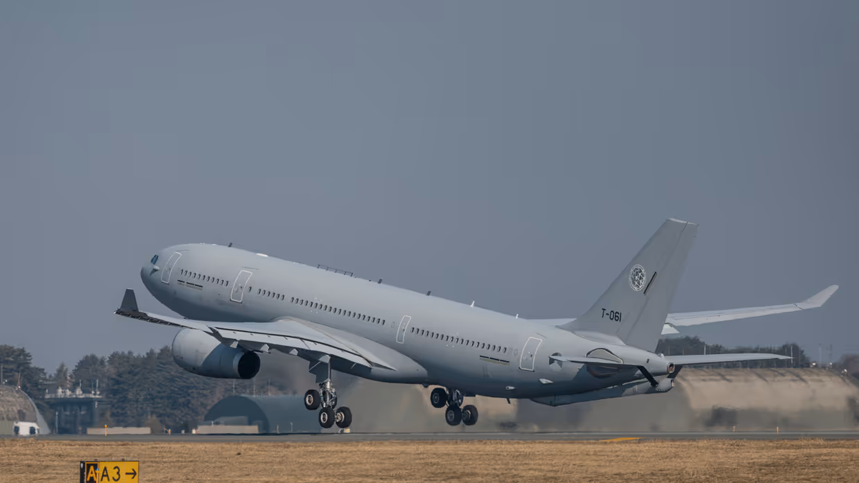 Het MRTT tankvliegtuig stijgt op. In de achtergrond zijn betonnen vliegtuigbunkers te zien.