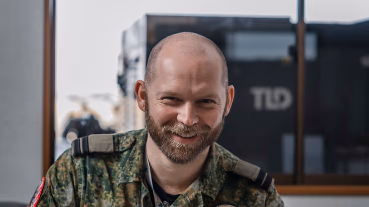 Portretfoto van kapitein Mark, gekleed in groen tenue.