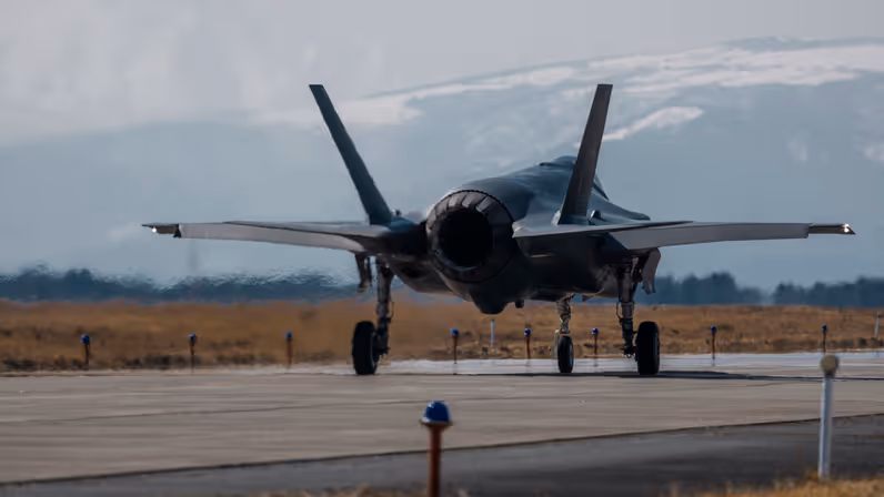Een Japanse F-35 taxiet. In de achtergrond zijn besneeuwde bergen te zien. 