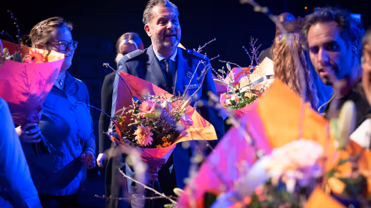 Majoor Toine Jongbloets ontvangt bloemen op het podium na afloop van het jubileumconcert.