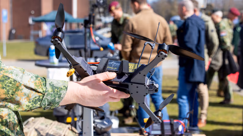 Militair houdt een kleine drone vast tijdens een demonstratie. 