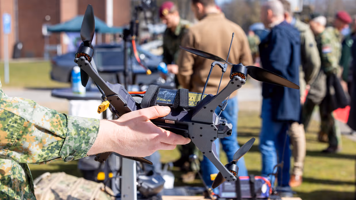Militair houdt een kleine drone vast tijdens een demonstratie. 