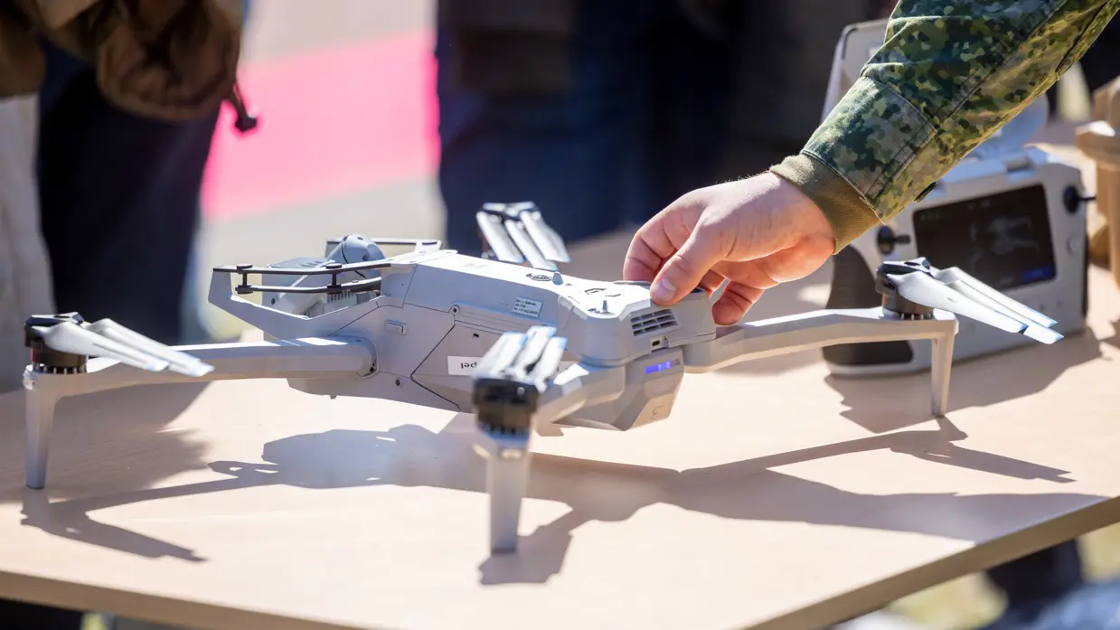 Militair toont een drone aan publiek tijdens een demonstratie. 