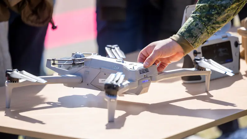 Militair toont een drone aan publiek tijdens een demonstratie. 