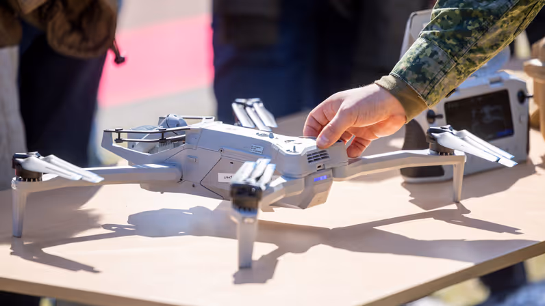 Militair toont een drone aan publiek tijdens een demonstratie. 