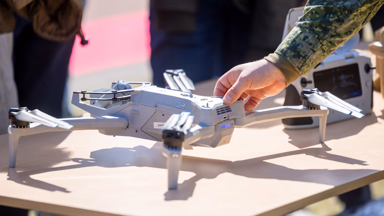 Militair toont een drone aan publiek tijdens een demonstratie. 