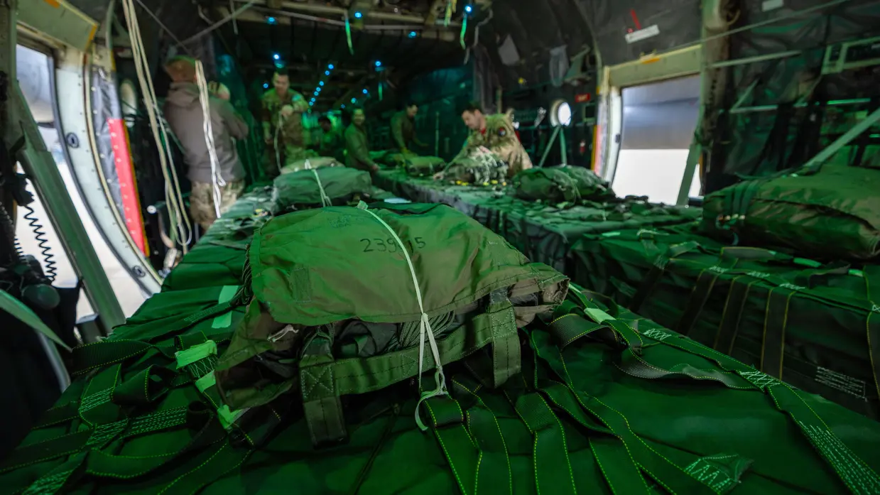 luchtmachtmilitairen zijn bezig met de vrachtbundels in het vliegtuigruim. 