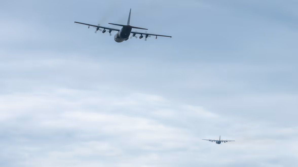 Twee transportvliegtuigen vliegen weg richting de horizon.