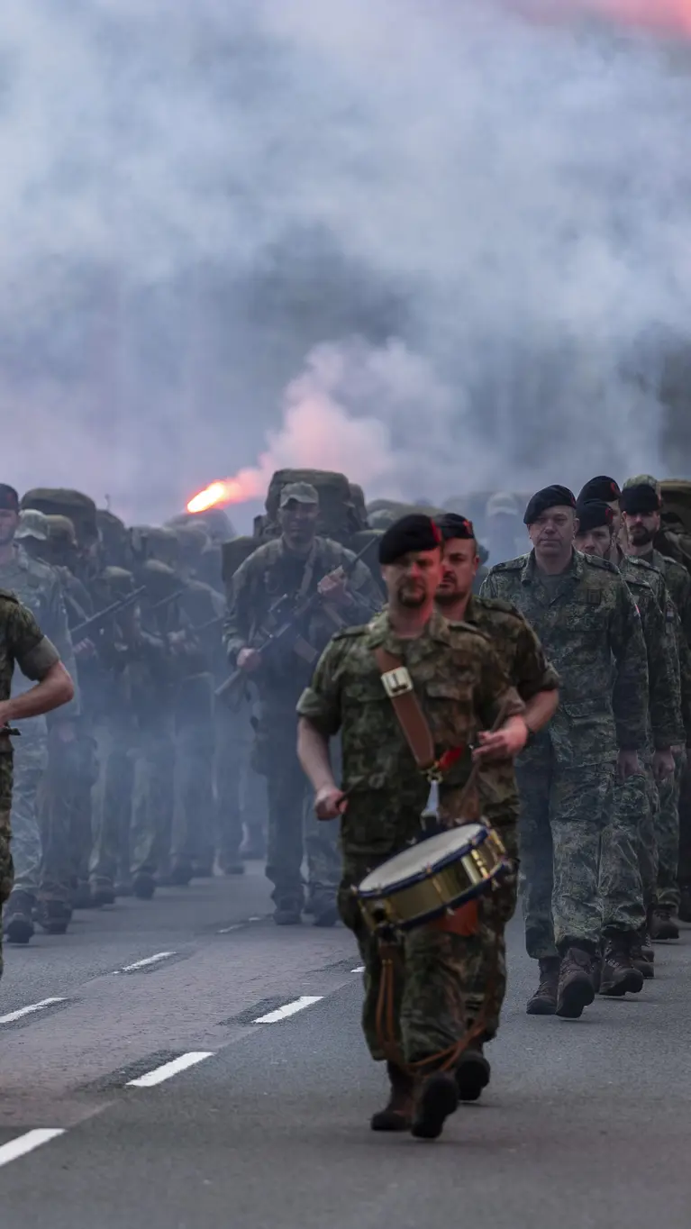 De nieuwe mariniers en hun kader komen aanmarcheren terwijl rode fakkels zijn ontstoken. 