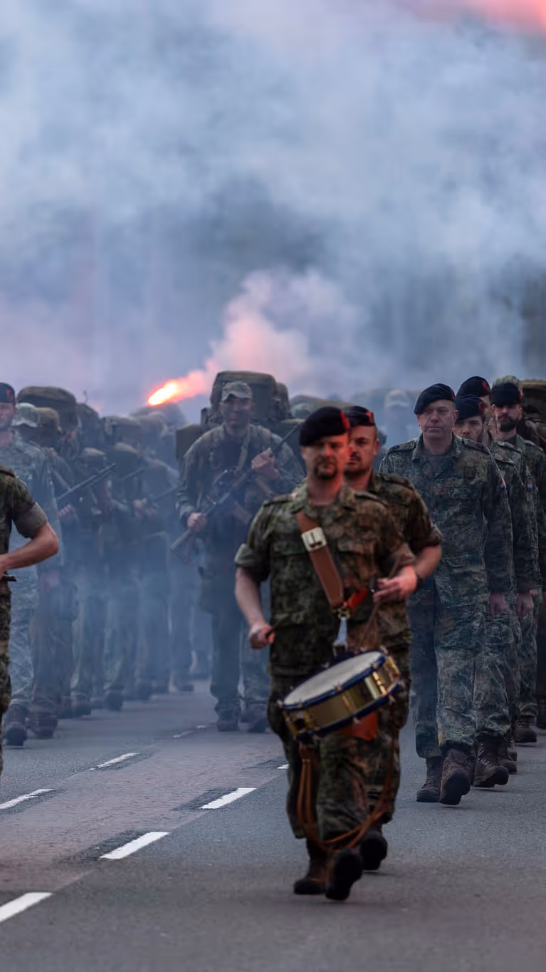 De nieuwe mariniers en hun kader komen aanmarcheren terwijl rode fakkels zijn ontstoken. 