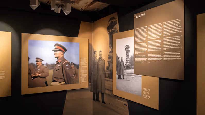 Een donkere expositieruimte, met daarin foto’s van een Poolse generaal met snor. Daarboven staat: Stasinek