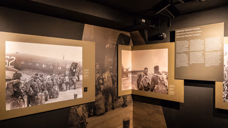 Twee zwart-wit foto’s op de expositie. Op de ene staan mannen die een vliegtuig in lopen, de ander vertoont Stasinek met parachutistentuig. Daarnaast is een plaquette te zien met uitleg over de Operatie Market Garden.