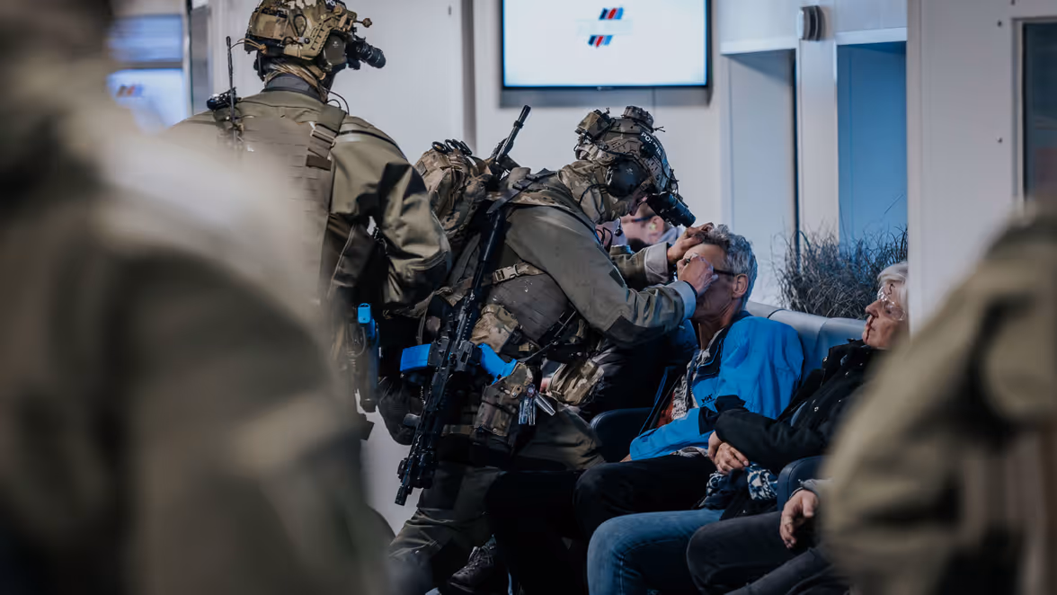 Een operator checkt de pupilreactie van een gewonde passagier aan boord van de veerboot.