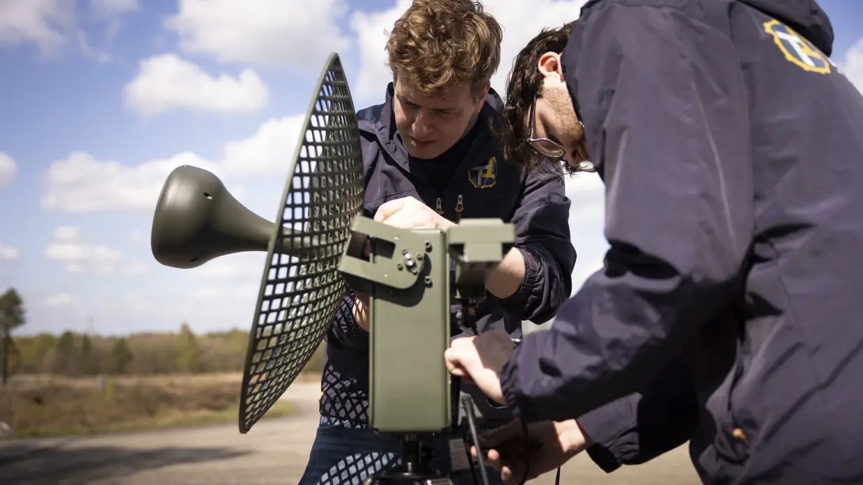 Personeel bezig met het optuigen van de antenne.  