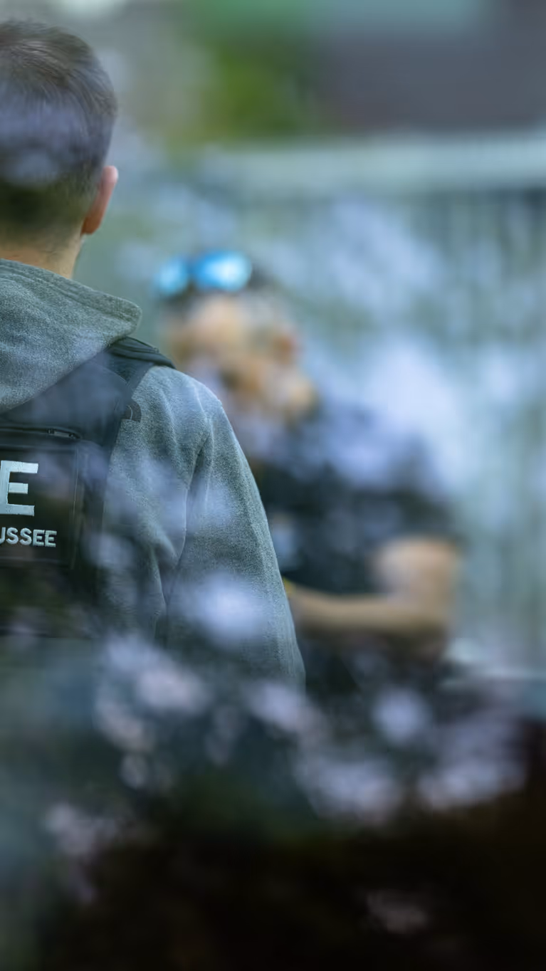 Een marechaussee in burger met een KMar-vest aan. 