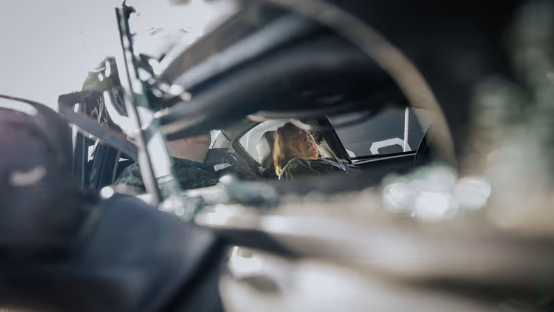 2 gewonden achter het stuur van een auto. De foto is door een zijraam gemaakt.  