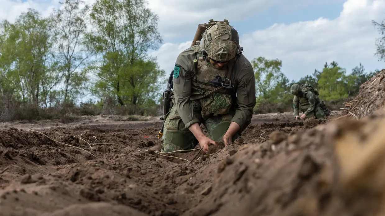 Militair bevestigt het draad aan de springstof.