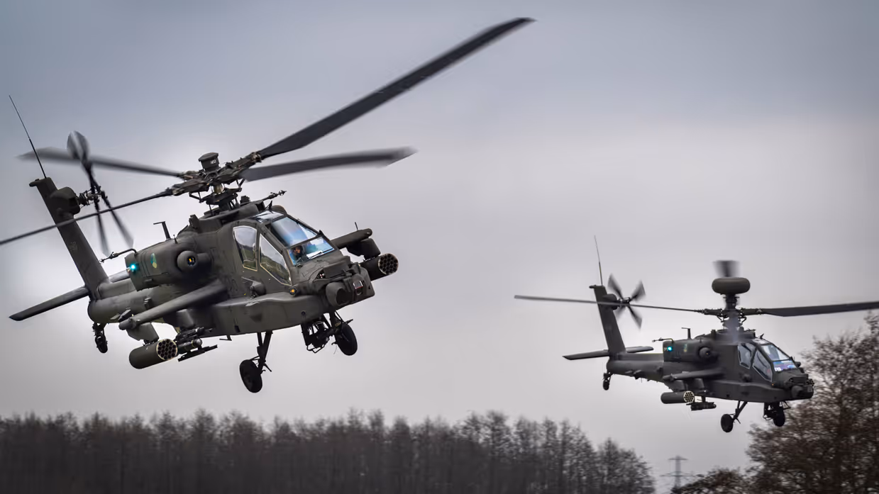 Twee Apaches laagvliegend boven begroeiing.