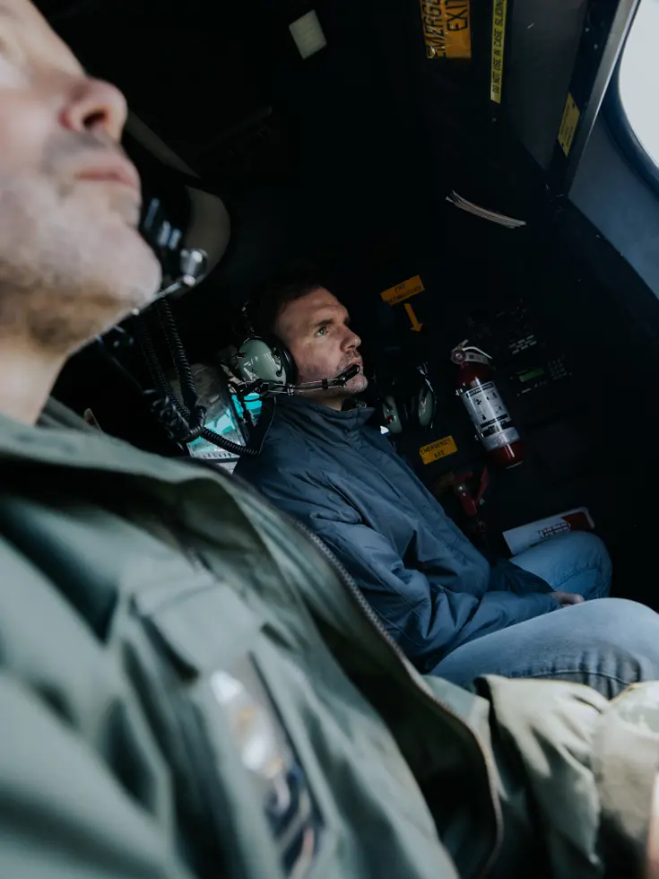  Boswijk naar buiten kijkend in een vliegende helikopter.