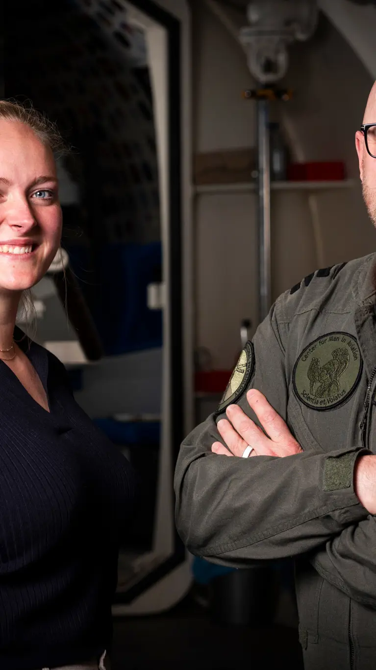 Vrouw in burgerkleding en man in militair uniform staan naast elkaar. 