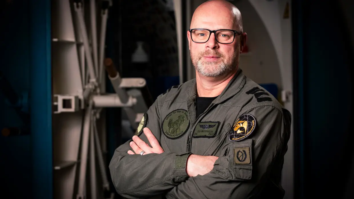 Militair met baard en bril kijkt vriendelijk in de camera. 