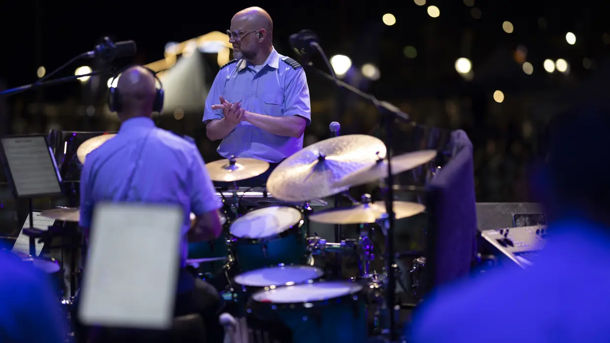 Dirigent klapt voor de drummer van het orkest. 