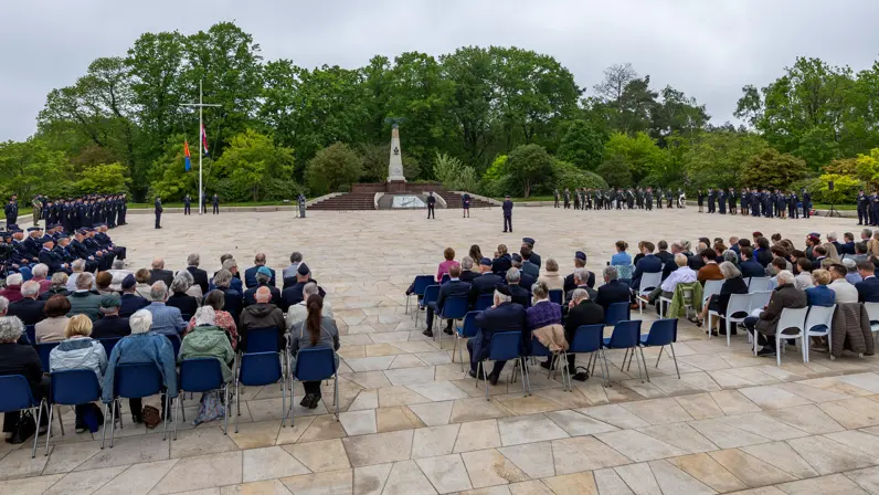 Overzicht van de herdenkingsplaats op de voormalige vliegbasis Soesterberg met in het midden het monument, links en rechts opgestelde luchtmachtmilitairen en in de voorgrond genodigden. 
