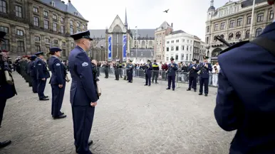Luchtmachtmilitairen staan opgesteld langs de looproute vanaf het Paleis op de Dam. In de achtergrond de Oude Kerk. 