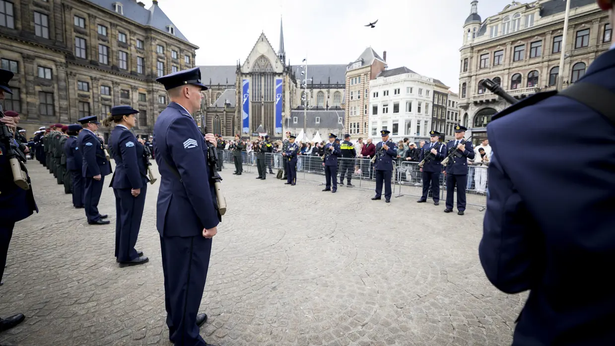 Luchtmachtmilitairen staan opgesteld langs de looproute vanaf het Paleis op de Dam. In de achtergrond de Oude Kerk. 