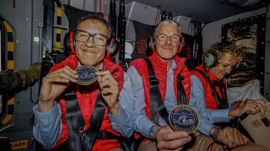 Twee leden van de Jostiband zittend in een NH90 met tonen hun patch ‘Josti Flight; Bevrijdingsdag 2026’.