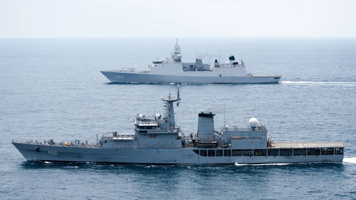 Op de voorgrond vaart een Indiaas marineschip, daarachter de De Ruyter.