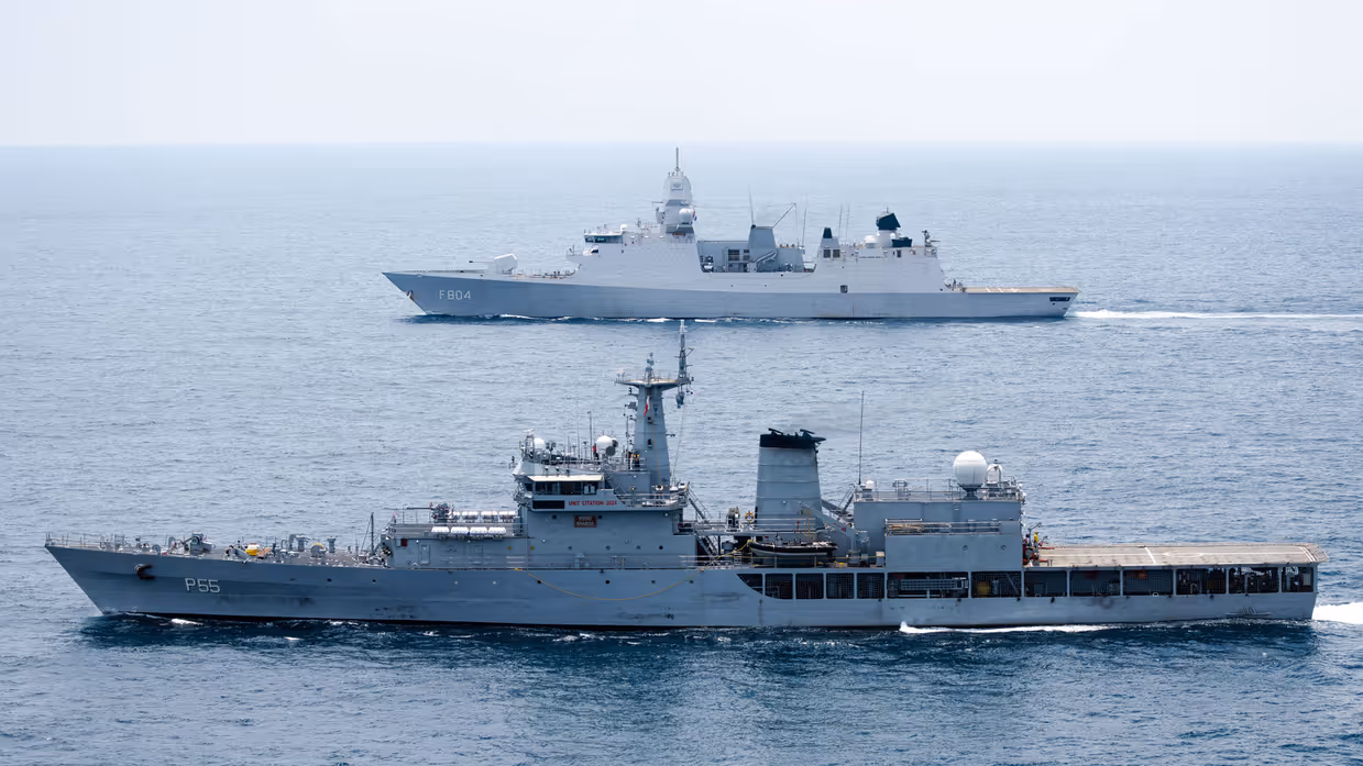 Op de voorgrond vaart een Indiaas marineschip, daarachter de De Ruyter.