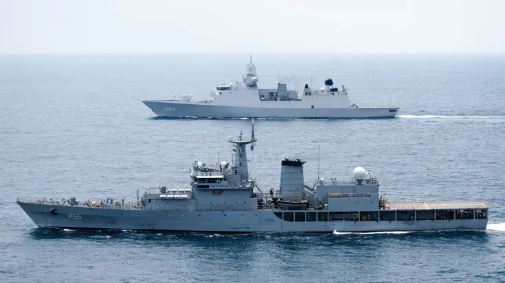Op de voorgrond vaart een Indiaas marineschip, daarachter de De Ruyter.