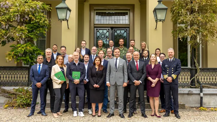 Groepsfoto van de staatssecretaris met werkgevers en reservisten.